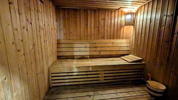 Eine Holzsauna mit Bänken und einer Sitzbank.