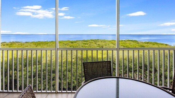 A balcony with a view of the ocean and a grassy hill. - South Seas Bayside Villa 5226 1 Bedroom Condo by RedAwning (Captiva)
