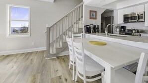 Eine moderne Küche mit weißen Schränken, Edelstahlgeräten und Holzboden.