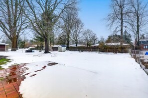 A snowy residential area with houses, trees, and a brick pathway. - Damaged Shower (Kalamazoo)