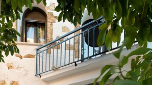 A traditional building with a balcony, arched windows, and potted plants. - Beit Petra Chania (Chania)