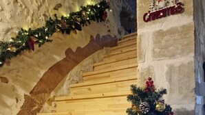 A wooden staircase with a Christmas tree decorated with ornaments and pinecones. - Beit Petra Chania (Chania)