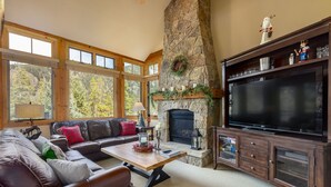 A cozy living room with a stone fireplace, large TV, and comfortable seating. - 6554 Settlers Creek 3 Bedroom Townhouse by RedAwning (Keystone)