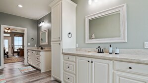 A modern kitchen with white cabinetry, a large island, and a built-in oven.