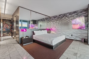 Une chambre à coucher moderne avec un lit, une table de chevet et un grand miroir.