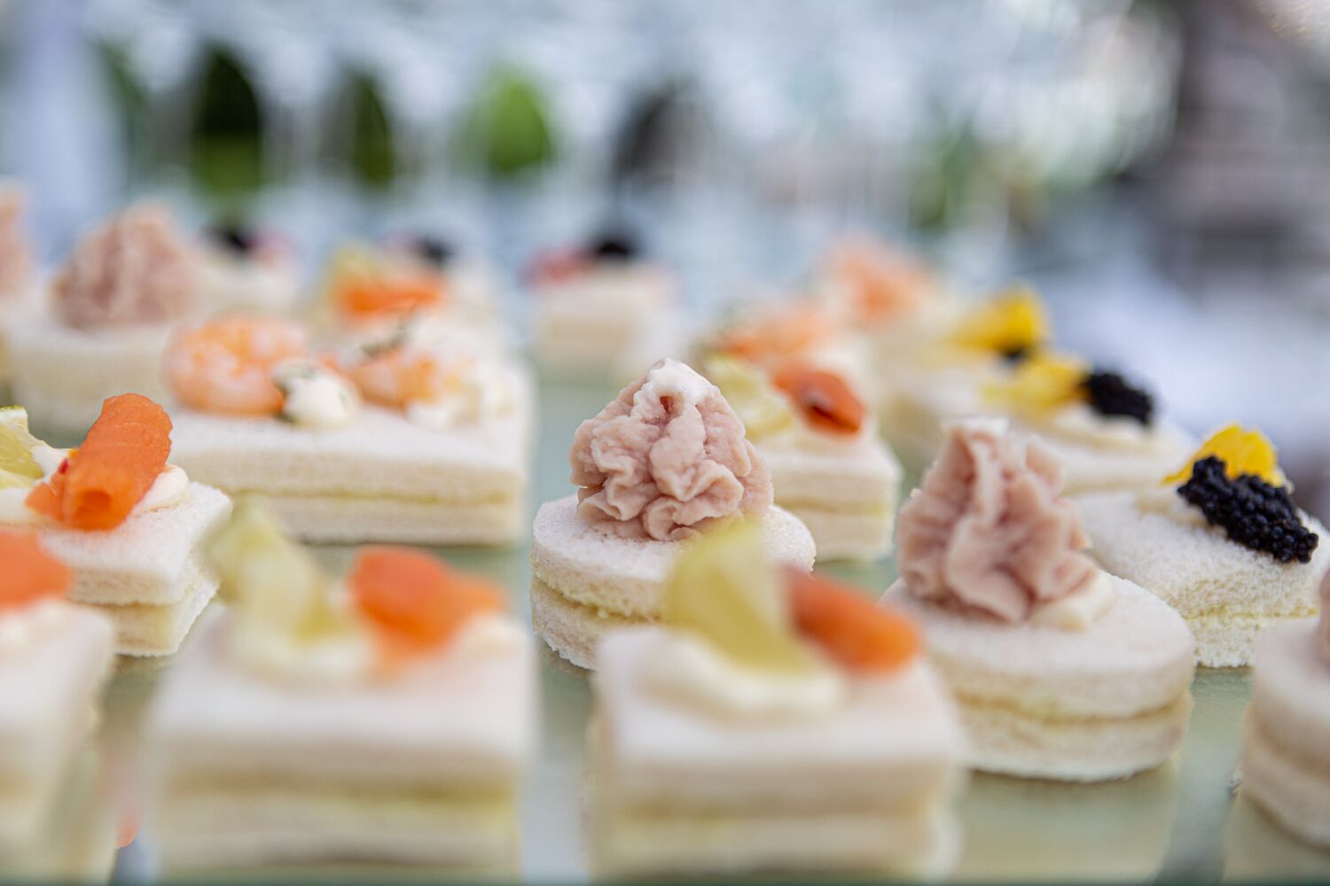 A variety of small, square-shaped desserts with different toppings.
