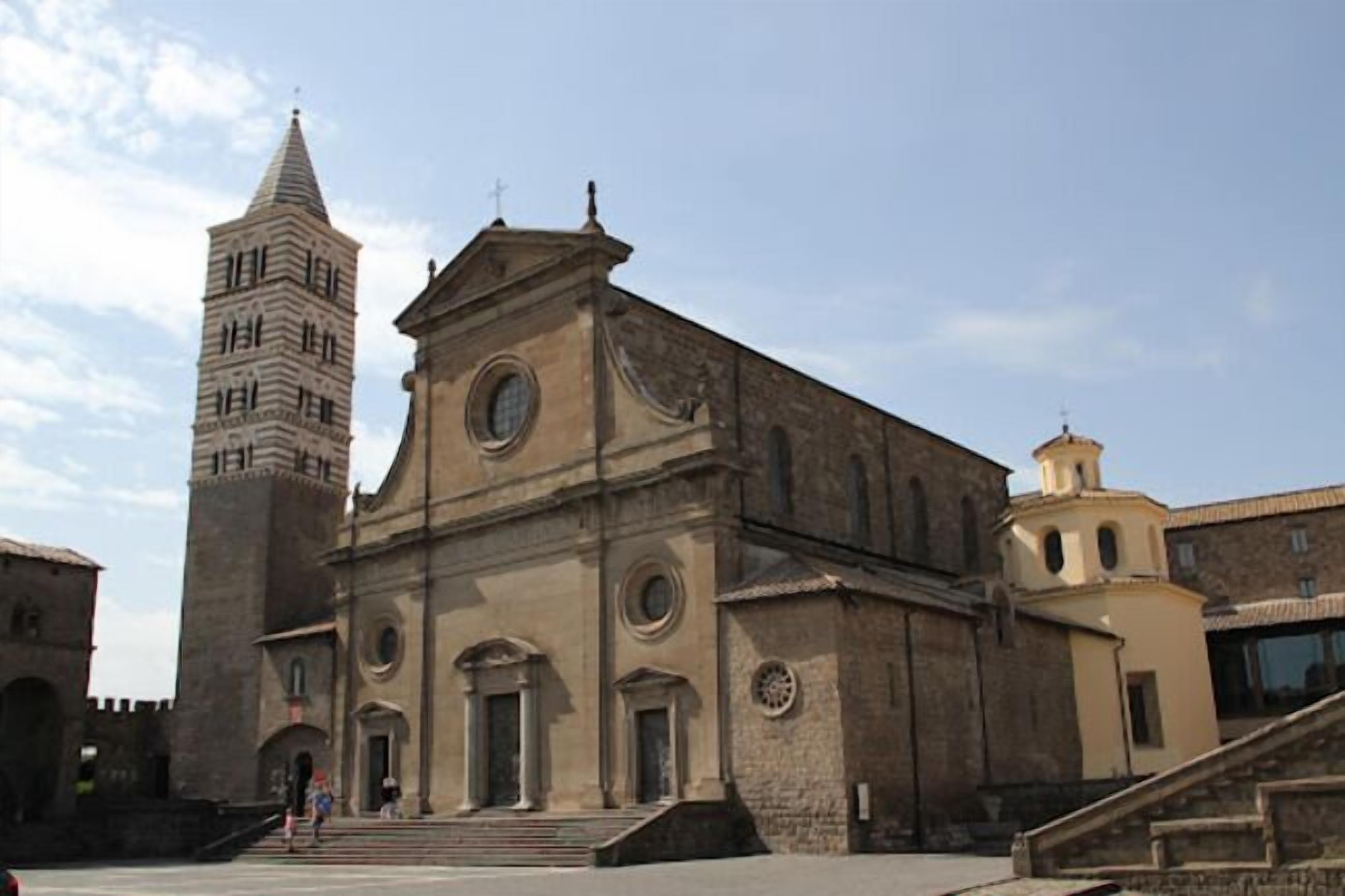 A historic building with a prominent tower and a central church facade.