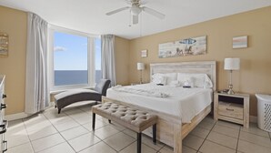 A hotel room with a large bed, a bench, a desk, and a view of the ocean. - FREE Beach Service, Golf + Perks! Emerald Beach 1430 Pool, Hot Tub &Starbucks (Panama City Beach)