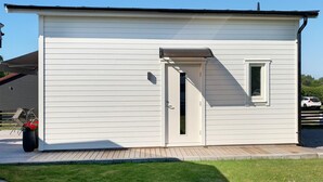 Un petit bâtiment d’un seul étage, à l’extérieur blanc, avec une porte d’entrée et une petite fenêtre.
