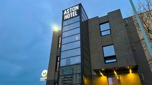 A modern hotel building with a prominent sign for the ASTON HOTEL. - Aston Hotel (Aktau)