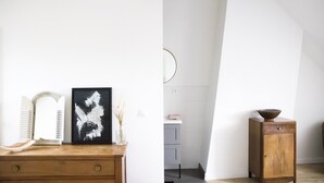 Ein Zimmer mit einem Holzkapelle, einem gerahmten abstrakten Gemälde und einer kleinen Holzkommode mit einer Schüssel darauf.
