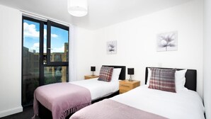 A bedroom with two beds, a large window, and artwork on the walls. - Absolute Stays on Essex-chinatown-hippodrome-alexandra Theatre-bull Ring-the Rep (Birmingham)