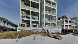 Un hotel di più piani fronte spiaggia, con balconi e una zona di spiaggia sabbiosa.