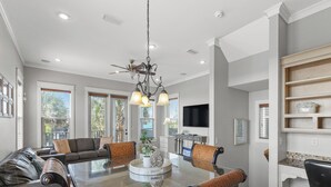 A spacious dining area with a glass-top table, surrounded by comfortable seating. - Salty Beach | Shared Pool + Easy Beach Access! (Panama City Beach)