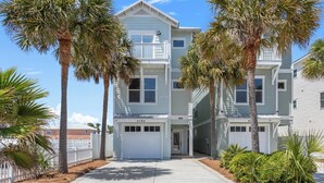 A multi-story residential building with a white exterior, a garage door, and a number "4120" on the front. - Salty Beach | Shared Pool + Easy Beach Access! (Panama City Beach)