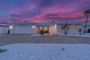 A two-story house with a garage, a covered patio, and a driveway.