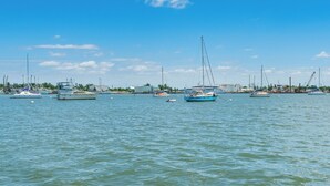 Eine Marina mit verschiedenen Schiffen an den Liegen, ruhigem Wasser und blauem Himmel.