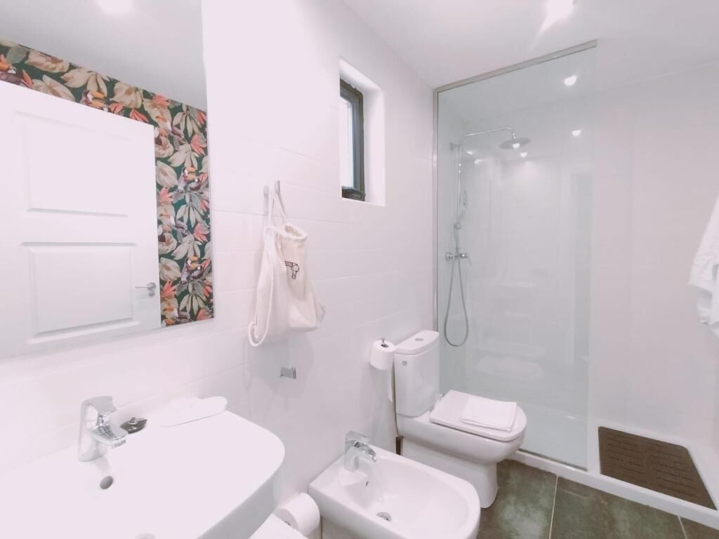 A modern bathroom with a toilet, bidet, and shower.