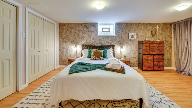 A bedroom with a large bed, a dresser, a nightstand, a window, and a door. - Pittsburgh Couple's Retreat ~ 2 Mi to Downtown! (Pittsburgh)