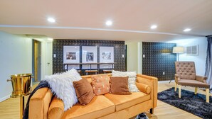 A modern living room with a sofa, a chair, a lamp, and framed pictures on the wall. - Pittsburgh Couple's Retreat ~ 2 Mi to Downtown! (Pittsburgh)