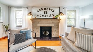 A living room with a fireplace, two sofas, and a sign above the fireplace. - Spacious Pittsburgh Getaway ~ 2 Mi to Downtown! (Pittsburgh)