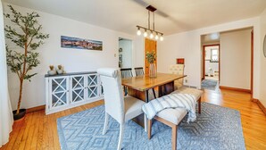 A dining area with a wooden table, chairs, and a bench. There is a potted plant, a cabinet with glass doors, and a painting on the wall. - Spacious Pittsburgh Getaway ~ 2 Mi to Downtown! (Pittsburgh)