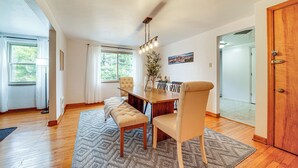 A dining area with a wooden table, cushioned bench, and a chandelier. - Spacious Pittsburgh Getaway ~ 2 Mi to Downtown! (Pittsburgh)