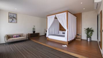 Un dormitorio moderno con cama con dosel, un sofá, una mesita de noche y una planta en maceta.