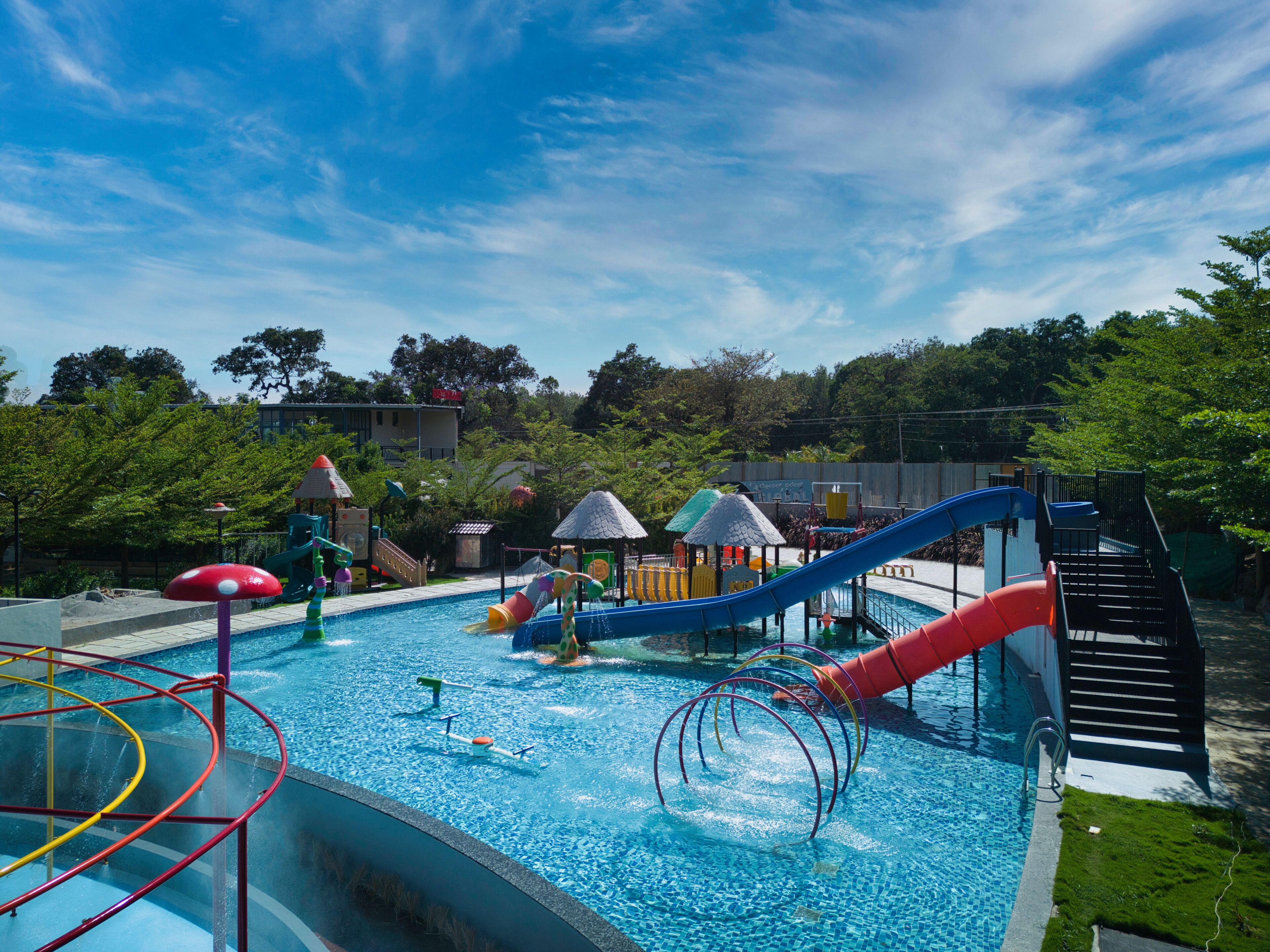 A swimming pool with slides and play structures.