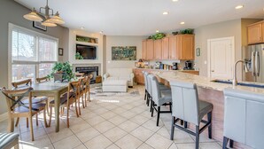 A spacious kitchen with a dining area, a fireplace, and a large window. - Large Tazewell Home < 1 Mi to Norris Lake Access! (Tazewell)