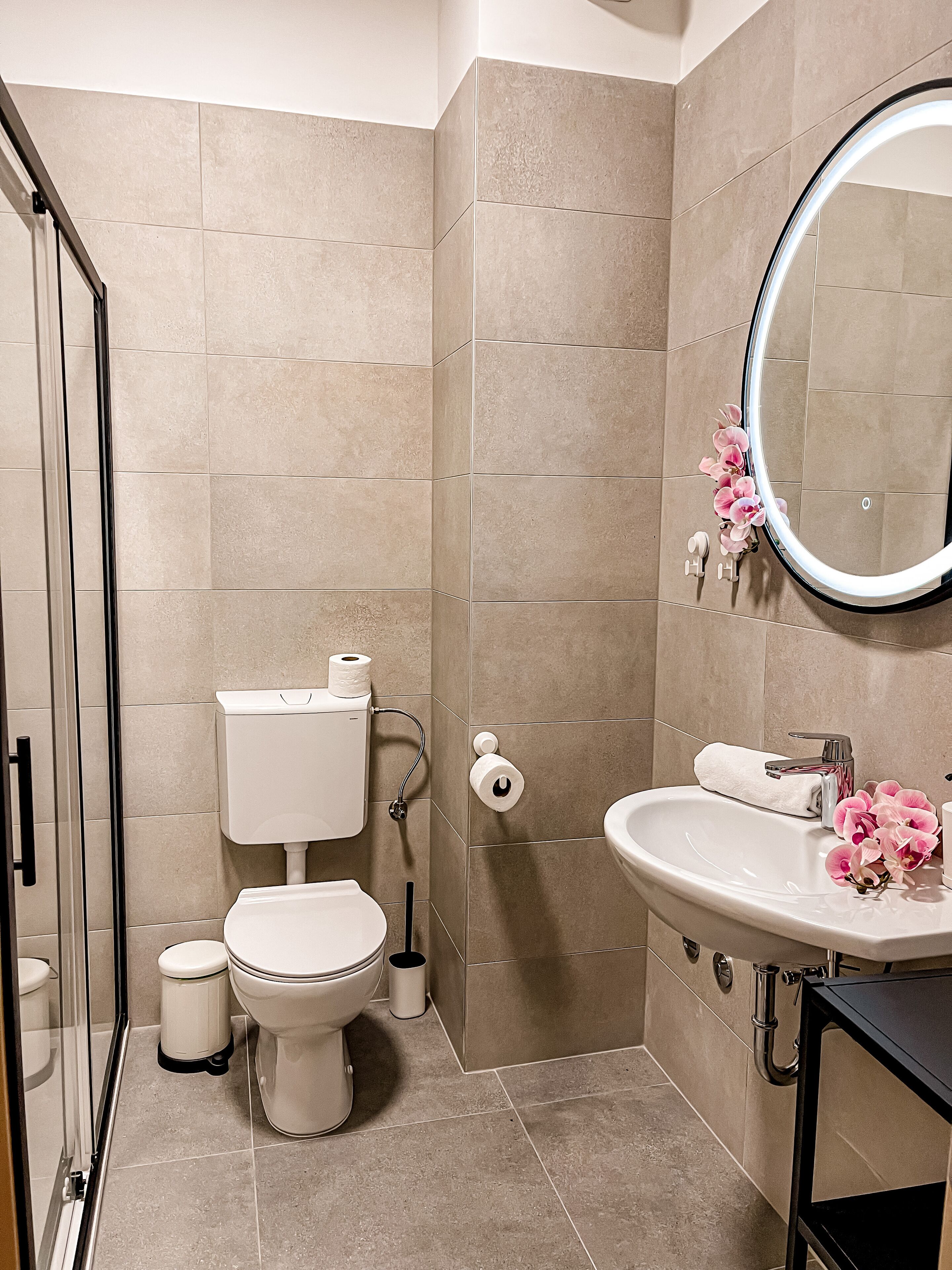 A modern bathroom with a toilet, bidet, and sink.