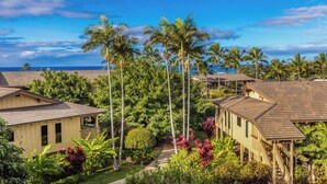 A coastal residential area with multiple houses, palm trees, and a clear view of the ocean. - Newly Renovated, Ocean Views, Minutes to Beach (Koloa)