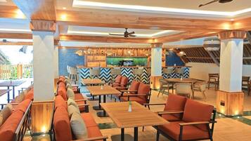 A restaurant with wooden furniture, a bar area, and a ceiling fan.
