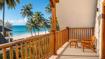 Un balcón con vista a la playa y palmeras.