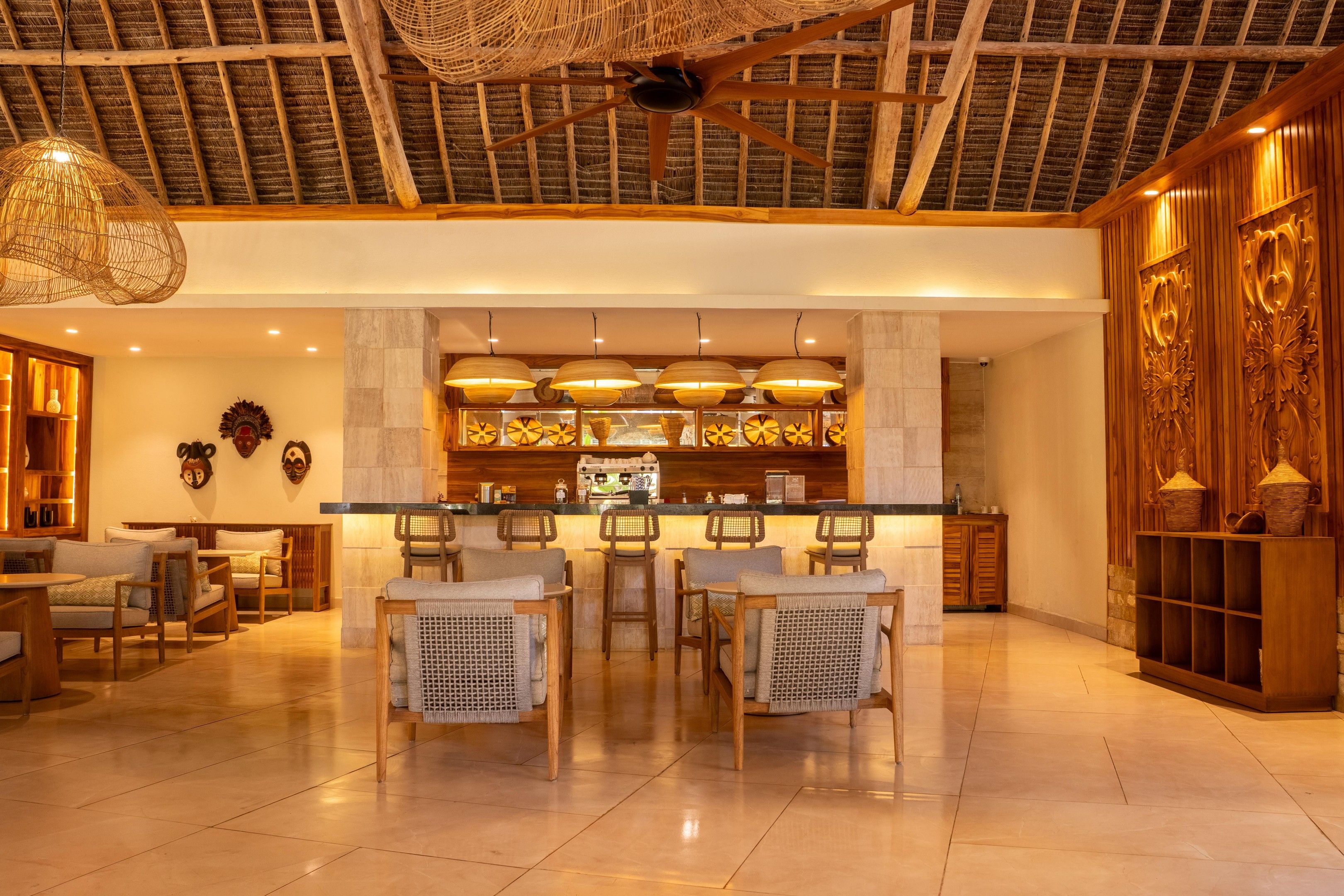 A spacious lobby with a high ceiling, a central bar area, and seating arrangements.