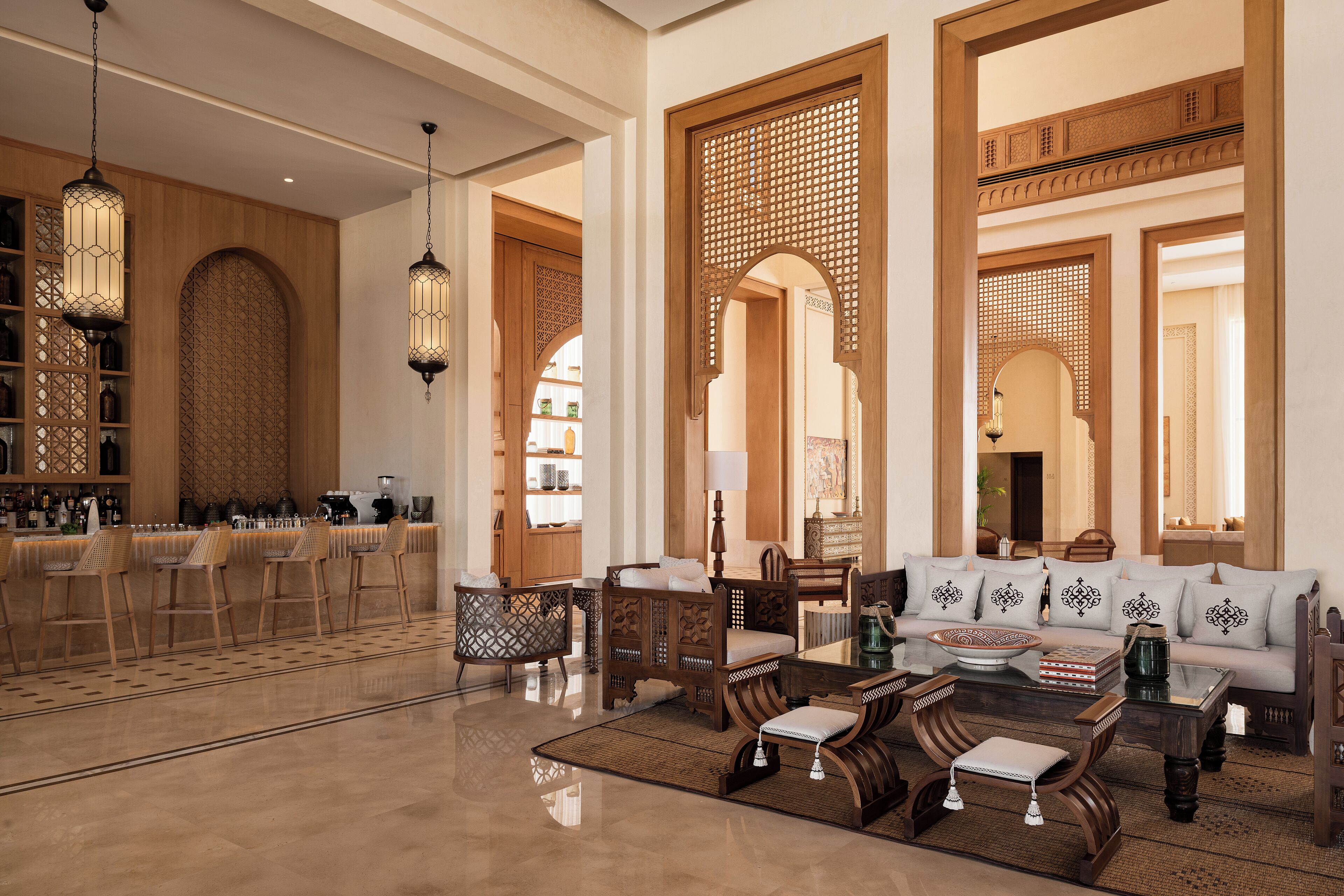 A spacious lobby with a bar area, seating arrangements, and decorative wooden panels.