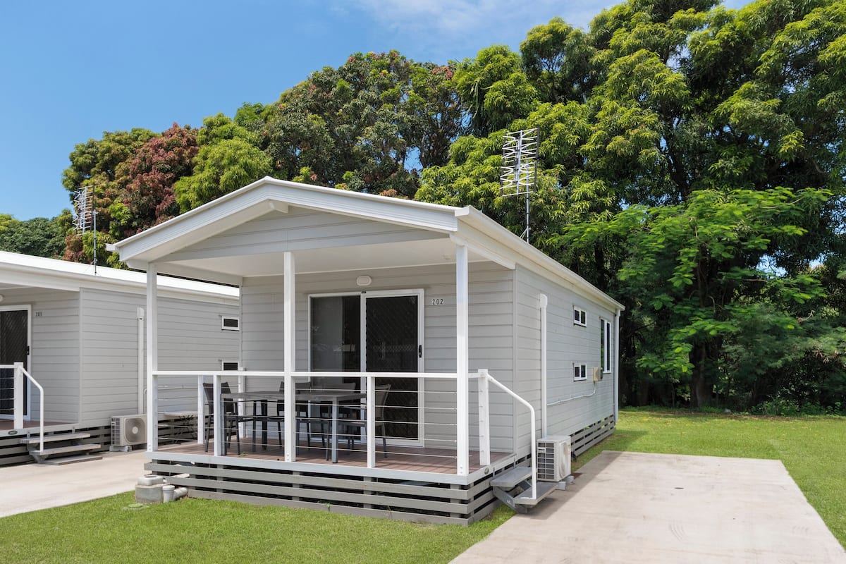 A single-story mobile home with a covered porch and a small deck area.