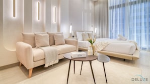 Une chambre d’hôtel moderne équipée d’un canapé, d’un lit, d’une table ronde et d’une table de chevet.