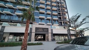 Un bâtiment moderne sur lequel on peut lire l’inscription « AZIZI RIVIERA 13 ».