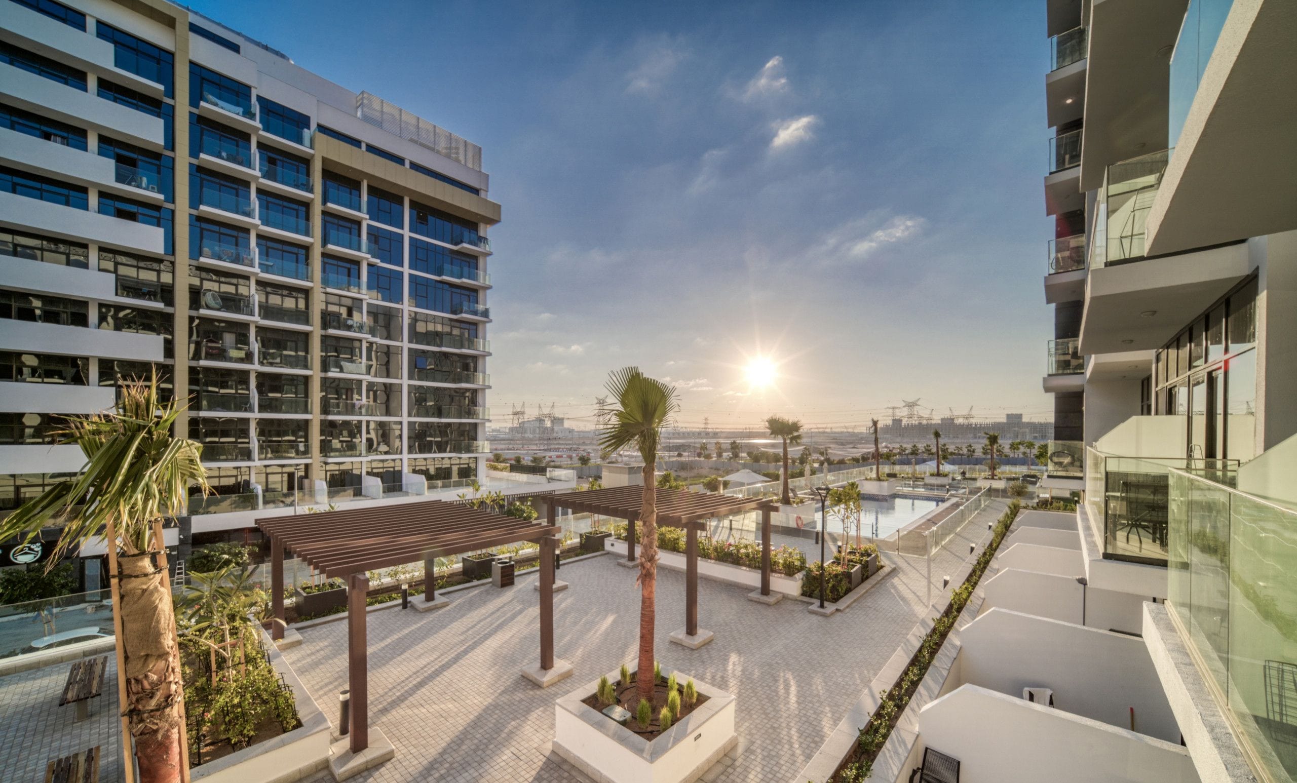 Un hotel moderno con piscina en la azotea, asientos al aire libre y vistas del horizonte de la ciudad.