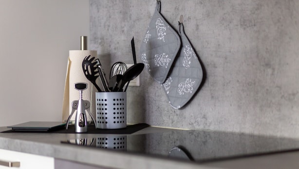 A kitchen counter with a utensil holder, a spatula, and a knife.