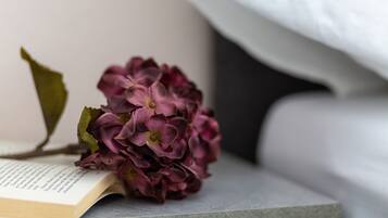 A book with a bouquet of purple flowers on a grey surface.