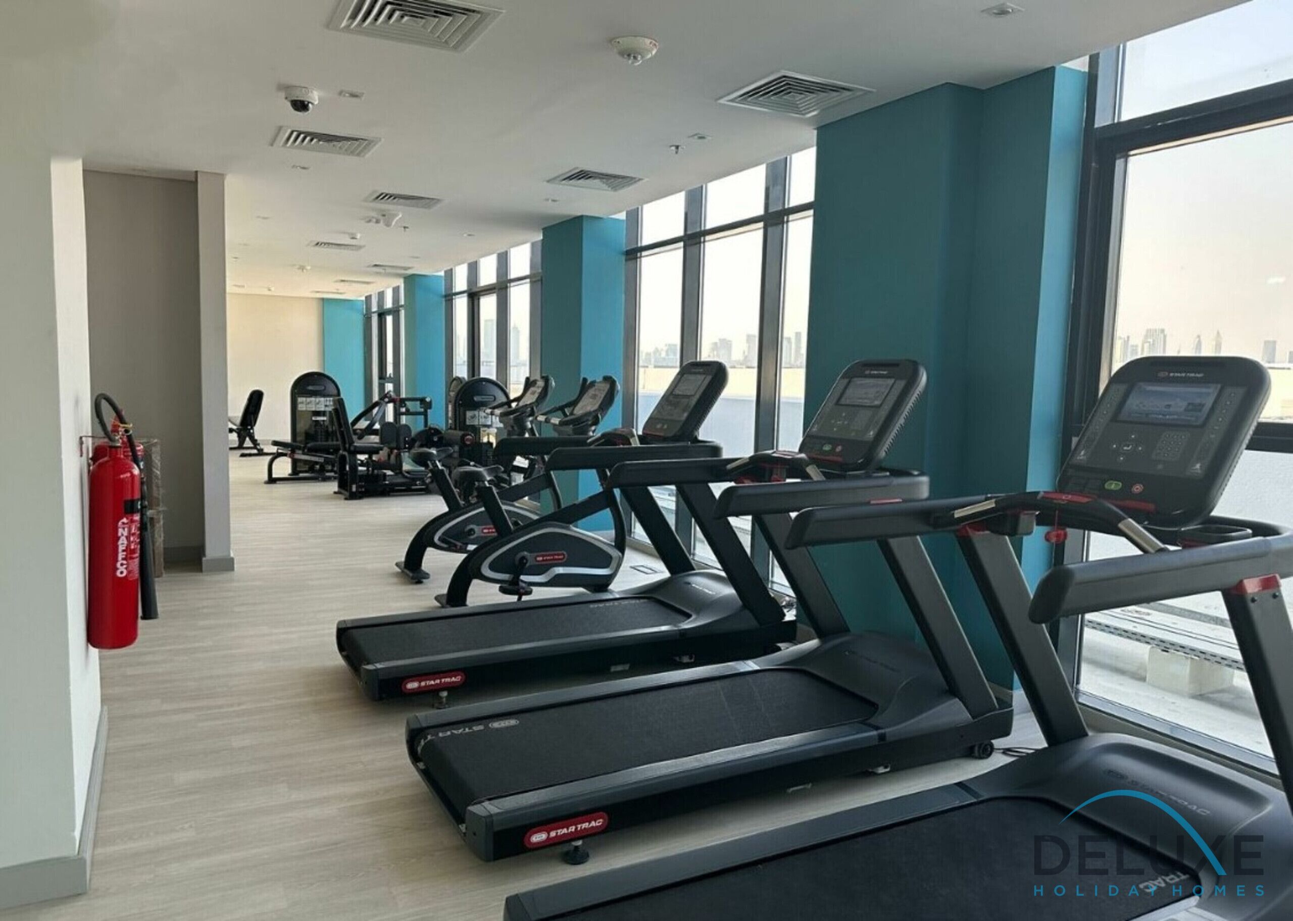 A gym with treadmills, exercise bikes, and weight machines.