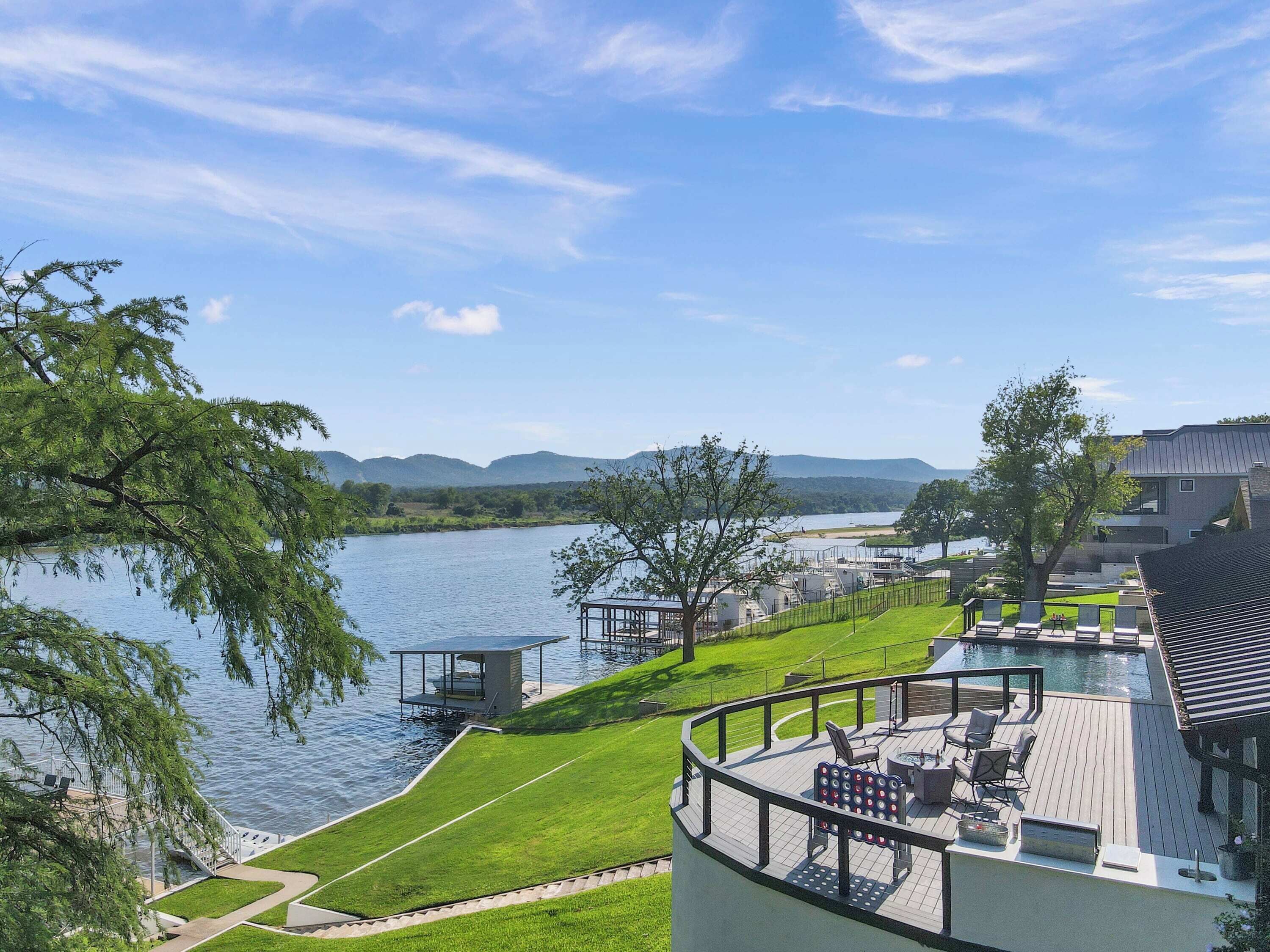 Une propriété située au bord du lac, dotée d’une terrasse, d’un espace salon extérieur et offrant une vue sur le lac et les montagnes.