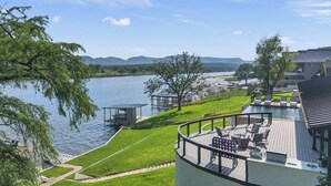 Ein Seeufergrundstück mit Terrasse, Sitzgelegenheit im Freien und Blick auf See und Berge.