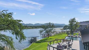 Une propriété située au bord du lac, dotée d’une terrasse, d’un espace salon extérieur et offrant une vue sur le lac et les montagnes.