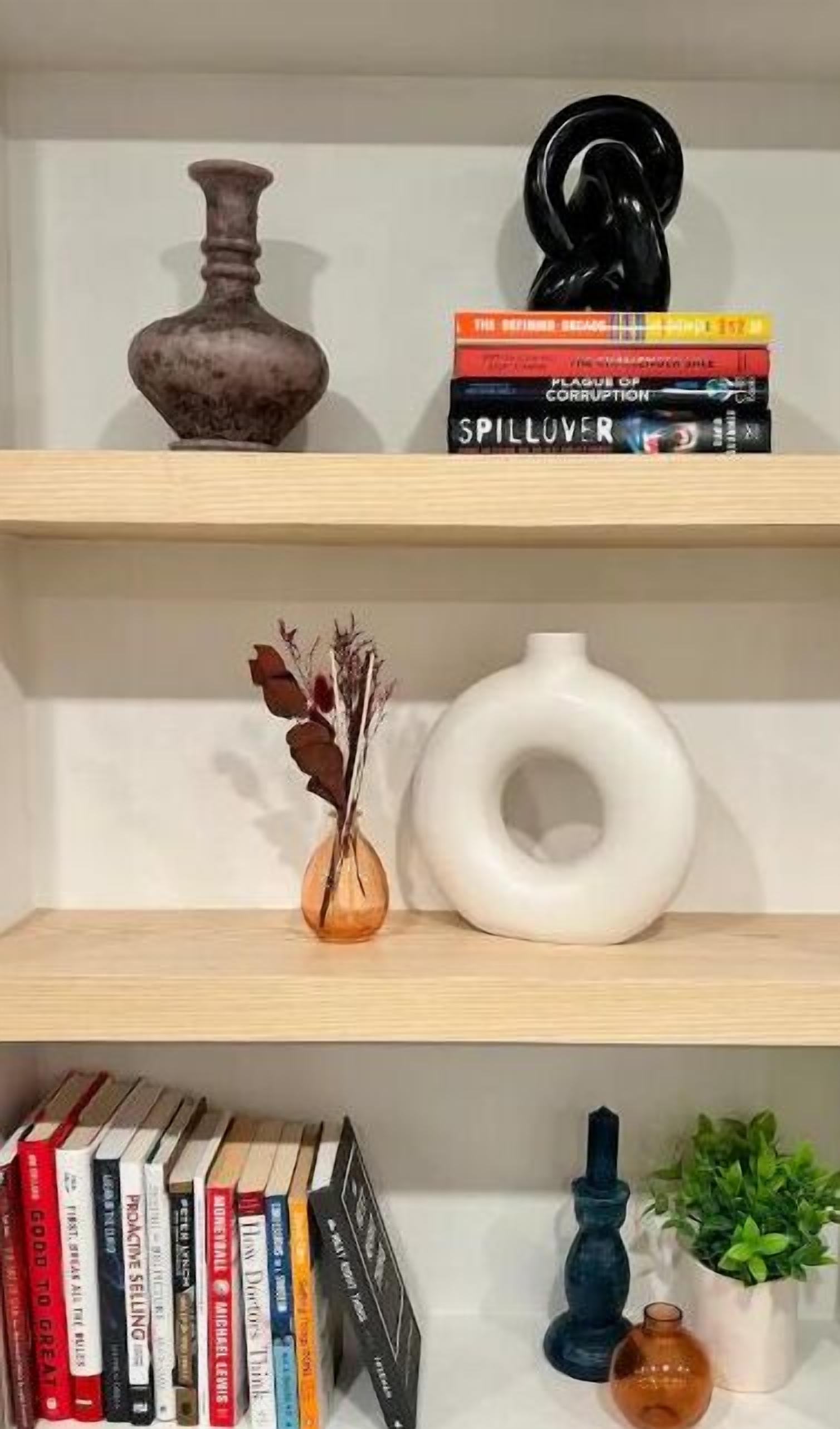 A bookshelf with books, decorative items, and a small plant.