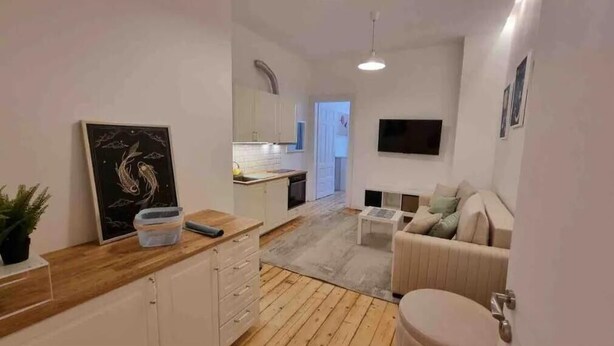 Een modern appartement met keuken, eethoek en zithoek.