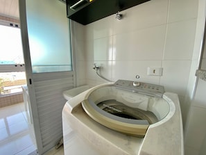 A bathroom with a bathtub, a window, and a shower. - Residencial Octávio Braga (Praia Grande)
