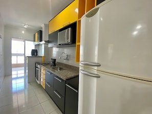 A modern kitchen with a refrigerator, microwave, and stove.